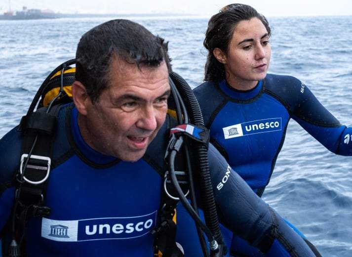 Deux plongeurs en combinaison UNESCO à la surface