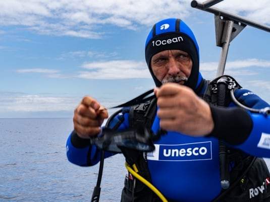 Plongeur en combinaison UNESCO donnant les consignes avant la mise à l’eau