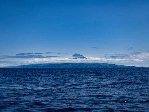 Le volcan de Pico émergeant des nuages, vu de la mer
