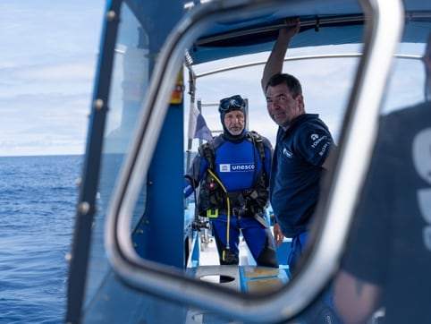 Deux plongeurs vus à travers le portique arrière du bateau