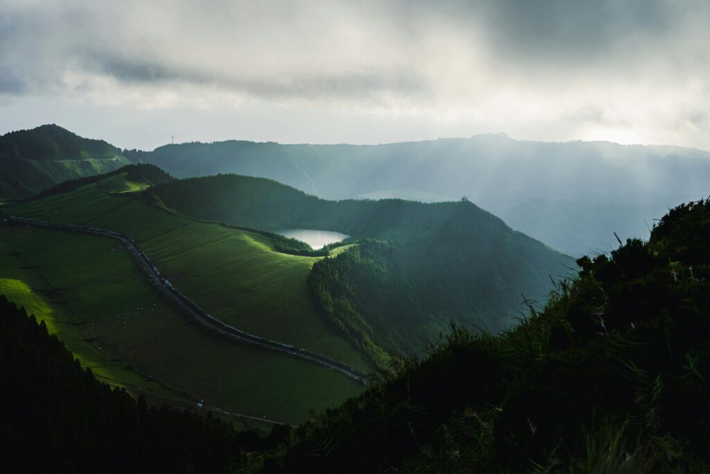 Breathtaking view of São Miguel, Azores with scenic mountains and sunlight streaming through clouds.